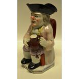An early nineteenth century Staffordshire Toby jug, wearing a tricorn hat, his face with patch