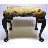 A George II style stool, the rectangular stuffed over seat covered floral needlework with brass