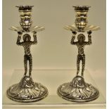 A pair of cast Harlequin figure tapersticks in mid eighteenth century style, supporting fluted