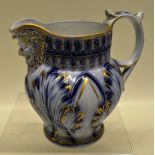 A mid nineteenth century Staffordshire cabbage leaf moulded blue and white jug, with a beaded mask