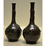 A pair of late nineteenth century Chinese bronze long neck bottle vases, the bodies applied a pair