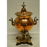 A Victorian copper tea urn, with a brass tap, a heater tube inside, two ribbed scroll handles,