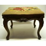 A Victorian walnut stool, the rectangular stuffed over seat covered in needle work, depicting a