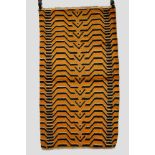 Tibetan rug, inner Asia, of angular stylized black and ivory ‘lip’ shaped tiger stripes on an orange