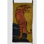 ‘The Look-out Cat’. Tibetan ‘tiger’ rug, inner Asia, first half 20th century, 4ft. 11in. x 2ft. 6in.