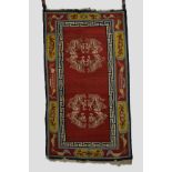 Tibetan rug, inner Asia, with dragon medallions on a red field, mid-20th century, 5ft. 1in. x 2ft.