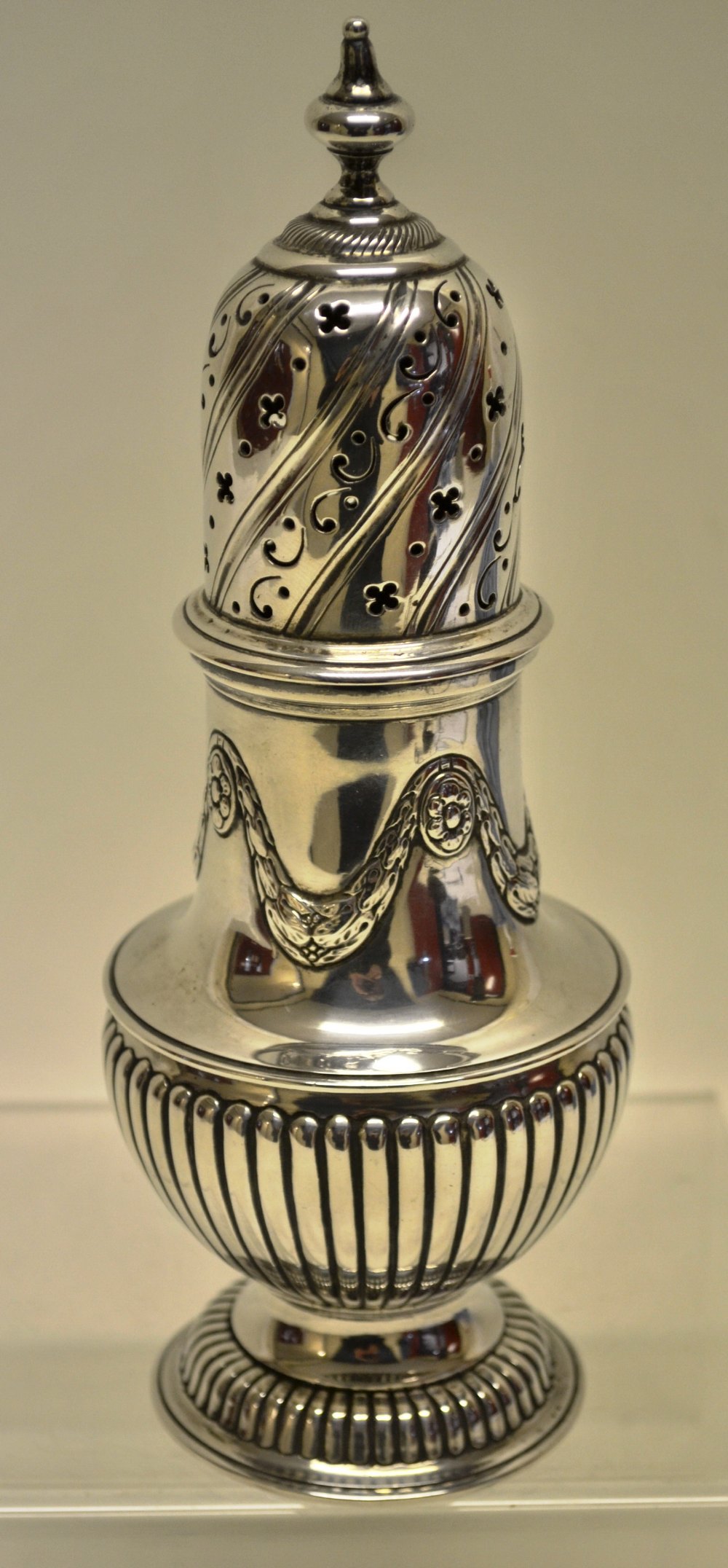 A late Victorian silver baluster sugar caster, partly ribbed body with patterae repousse swags, a