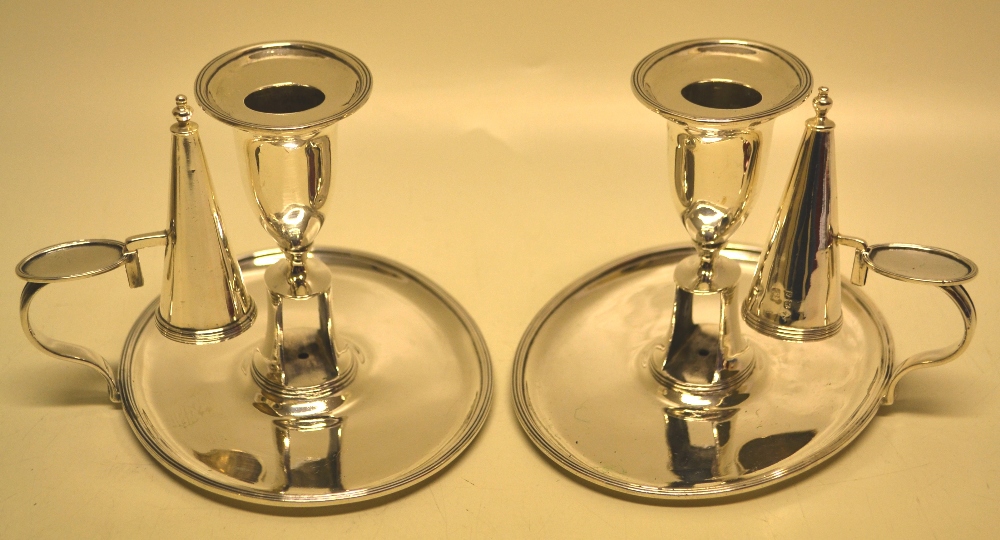 A pair of George III oval silver bedroom candlesticks, the candleholders with detachable nozzles and