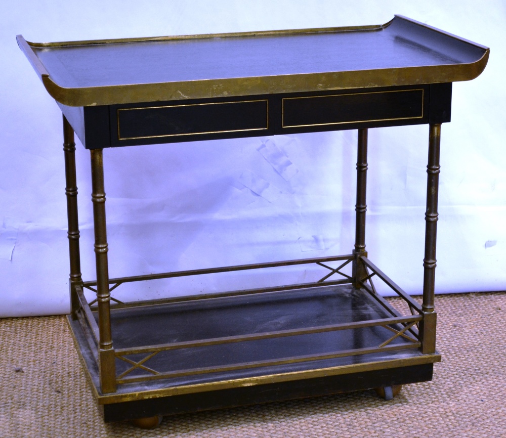An ebonised and brass mounted supper trolley, in oriental style, the top with end lifts above two
