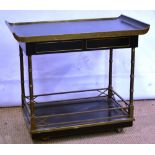 An ebonised and brass mounted supper trolley, in oriental style, the top with end lifts above two