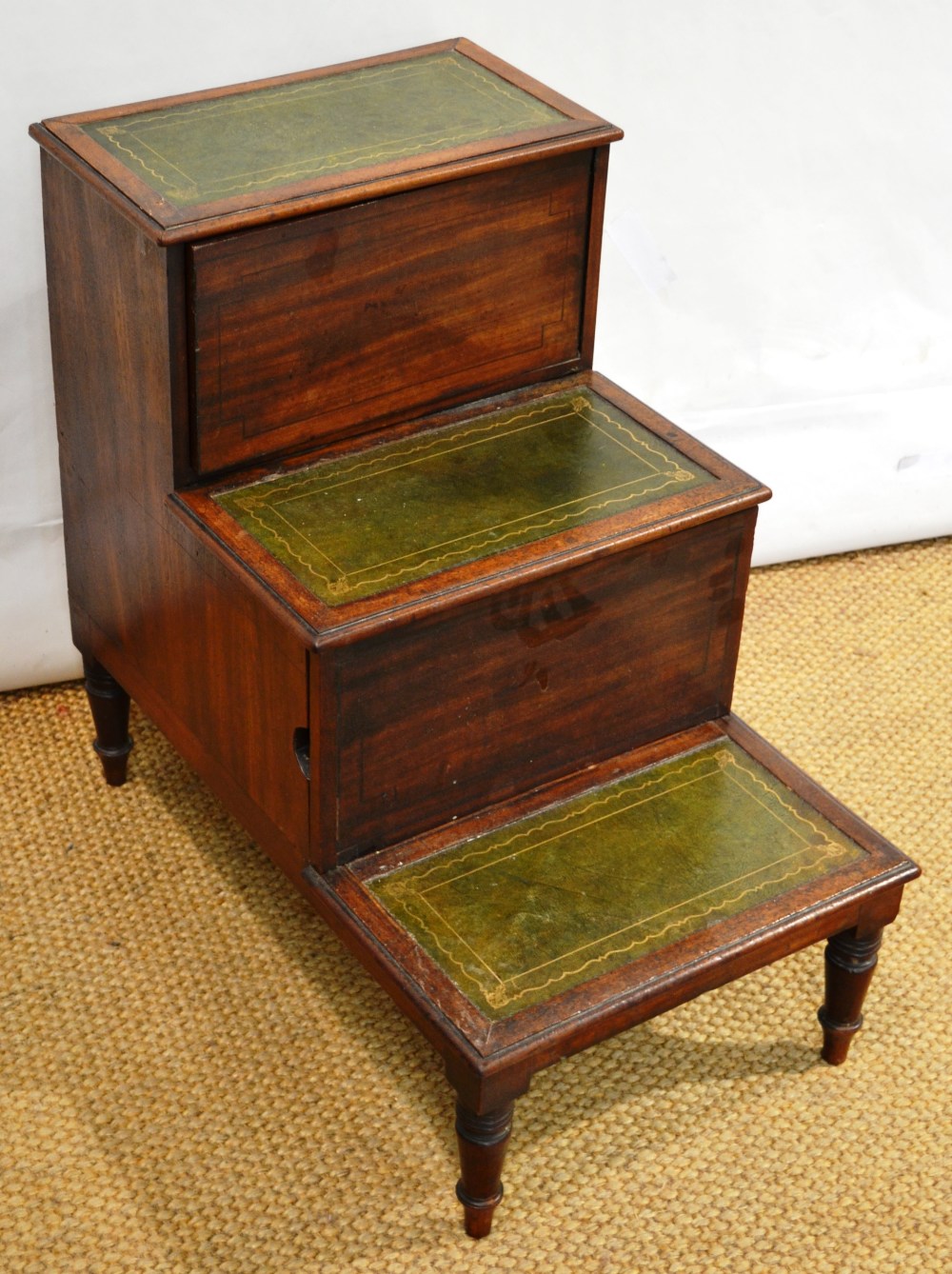 A Regency mahogany bedsteps night commode, the treads inset green gilt tooled leather, the centre