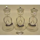 A set of three George V glass whisky tots with hinged silver covers, together with a set of four