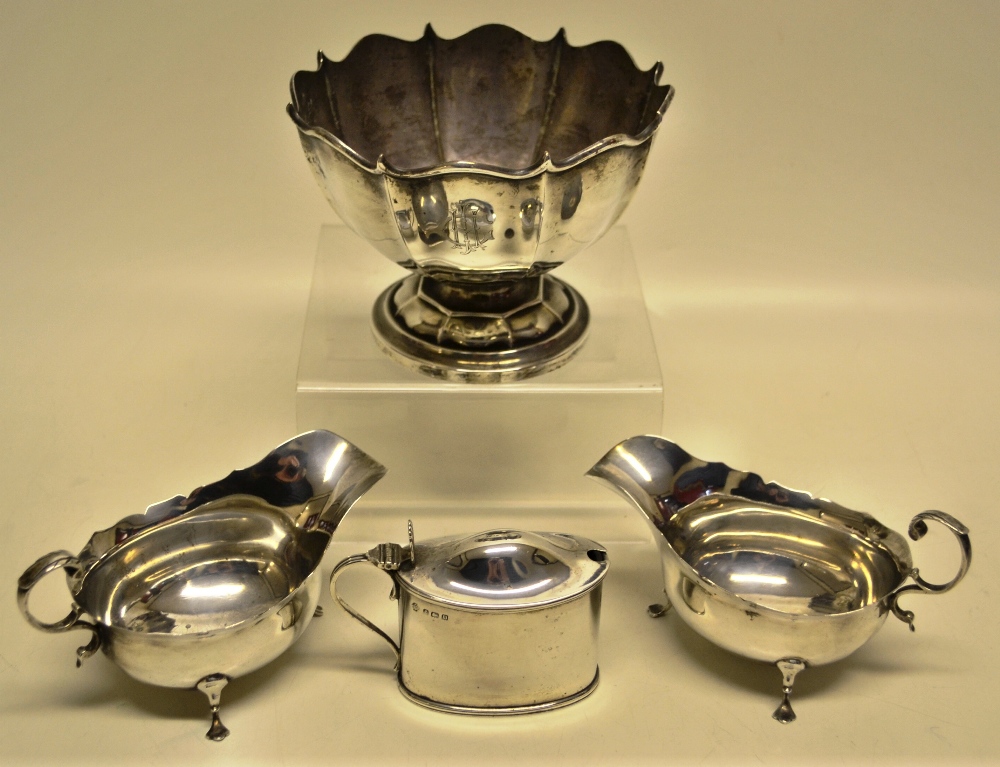 A pair of Edwardian silver oval cream boats with fretwork rims, flying leaf capped scroll handles,