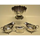 A pair of Edwardian silver oval cream boats with fretwork rims, flying leaf capped scroll handles,