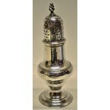 A George III silver baluster muffineer with a pierced cover, a flame finial, on a spreading foot.