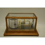 An early twentieth century oak glazed cased barograph, with ivory thermometer. 14in (36cm).