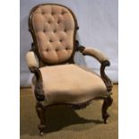 A Victorian walnut foliage carved show frame open armchair, the upholstered buttoned back with