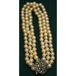 A cultured pearl necklace, three rows uniform size knotted throughout onto an emerald and diamond