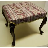 A Victorian walnut stool, the stuffed over seat on foliage carved cabriole legs with scroll toes.