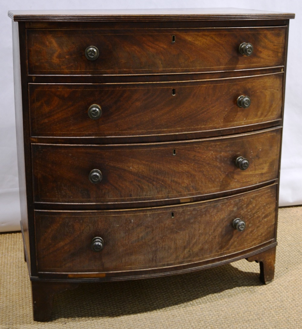A Regency mahogany veneered bow front chest, inlaid stringing, the reeded edge top above four long