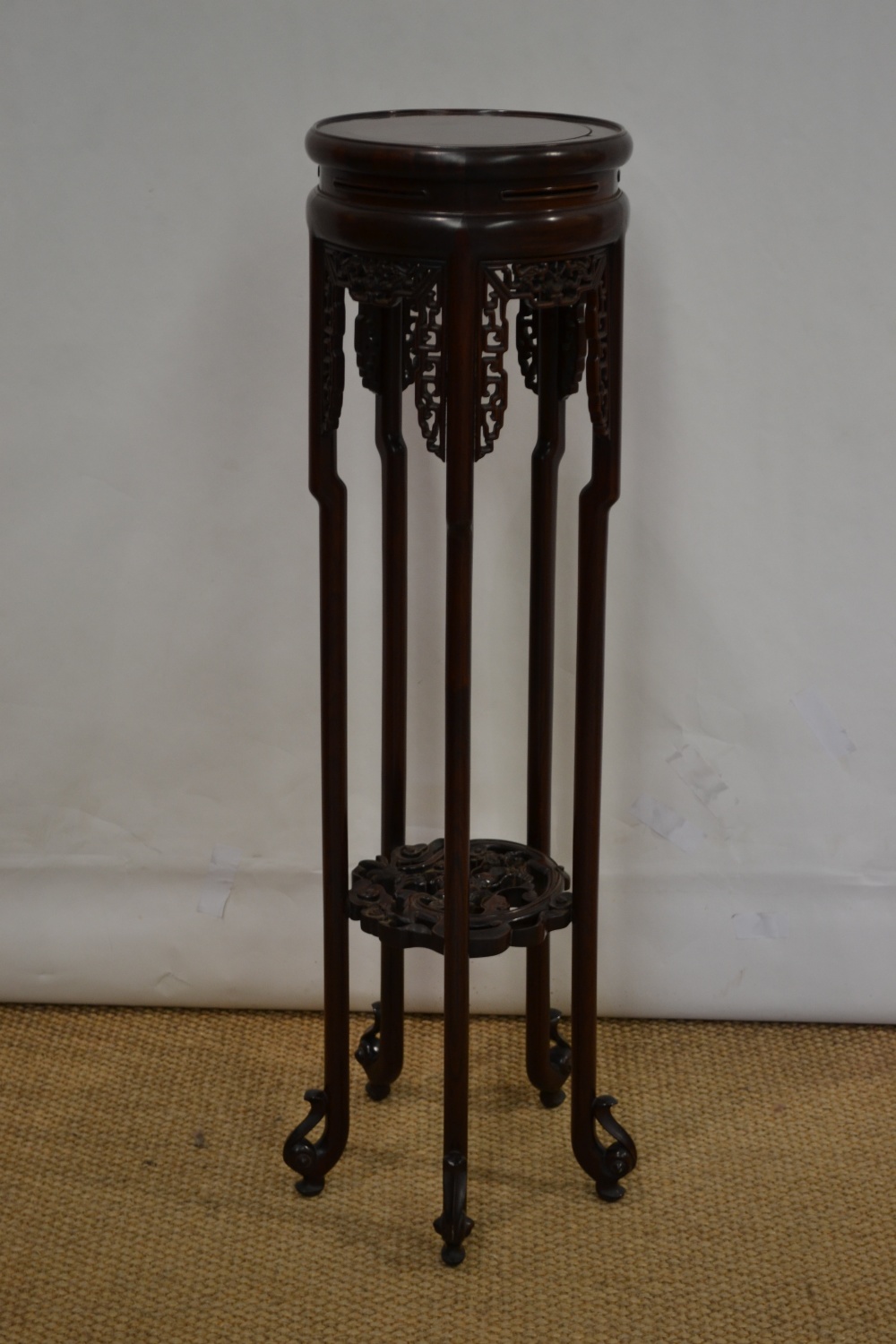 A Chinese hardwood jardinière stand, the circular top with pierced friezes, the legs supported by