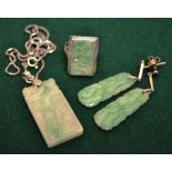 An mottled green jade plaque ring, having rectangular carved and pierced plaque set in white metal