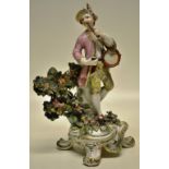 A Chelsea Derby porcelain figure of a musician, blowing a flute and beating a tambourine (