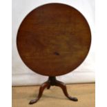 A George III mahogany circular tilt top table, on a vase turned stem to three cabriole legs, on club