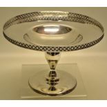 A George V silver circular tazza, the welled dish with a raised pierced trellis border, on an