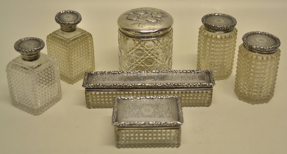 A Victorian cut glass set of toilet boxes and bottles with silver lids, engraved initials, foliage