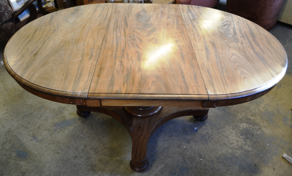 An early Victorian faded mahogany single pedestal dining table, the half round ended extending top