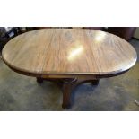 An early Victorian faded mahogany single pedestal dining table, the half round ended extending top