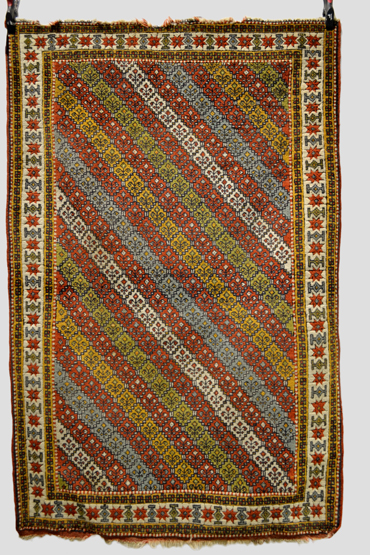 Quchan Kurd rug with multi-coloured diagonal striped field and an ivory star and medallion main