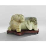 Chinese Carved Hardstone Figure of a Dog on Stand, late 19th/early 20th century, in a recumbent pose