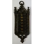 A small French Gothic style hanging weekly planner, with small indents for each day of the week,