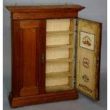 A wall mounted cigar cabinet with flared cornice and deep frieze enclosed by a pair of panelled