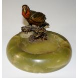 An onyx ashtray mounted with a cold painted parrot, 13cm diameter,