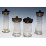 A set of four brass and glass cylindrical sweet jars,