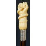 An ivory topped walking stick finely carved with a hand and snake, plain silver collar,