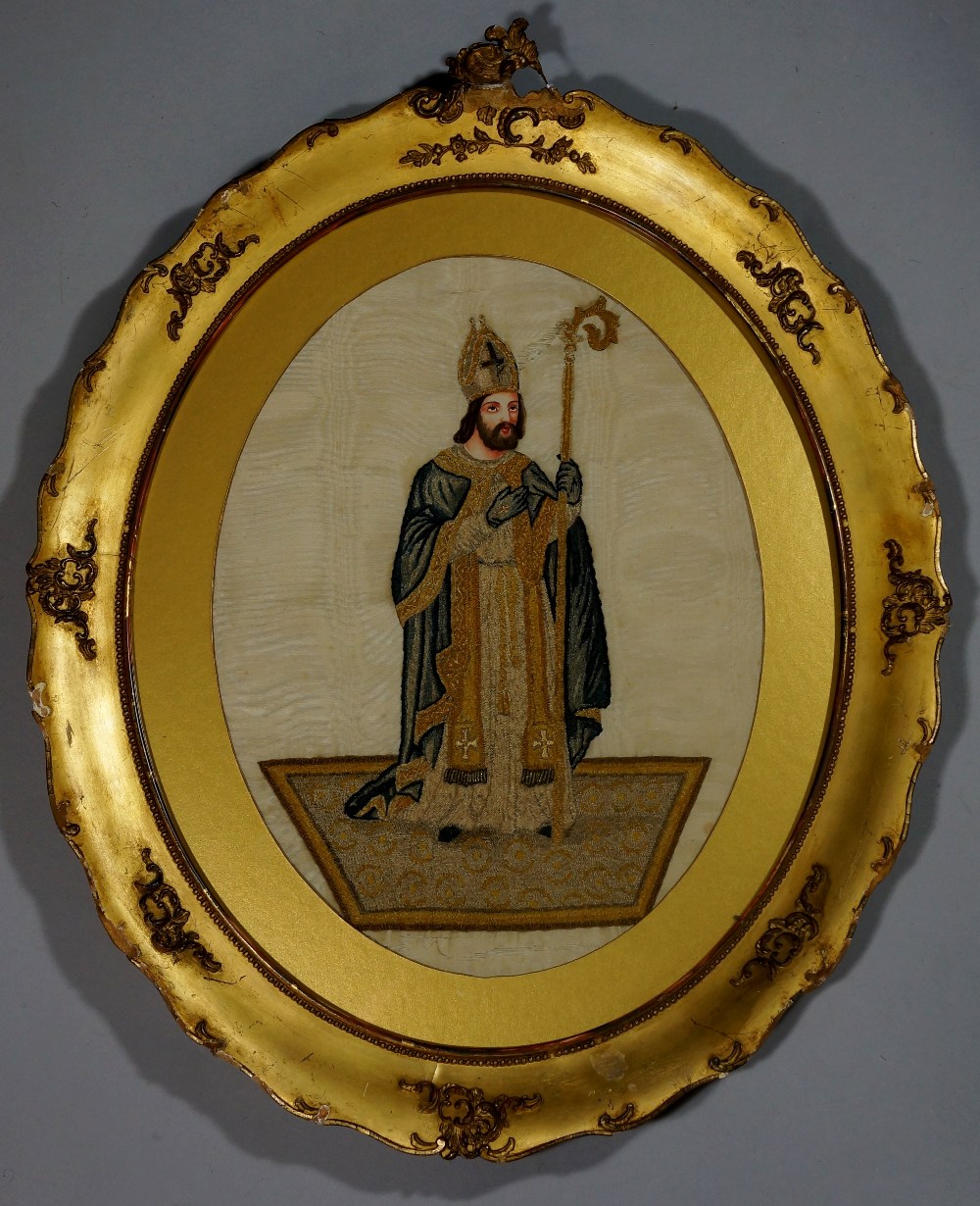 A 19th Century French needlework picture of a Saint finely worked in coloured silks and wools with