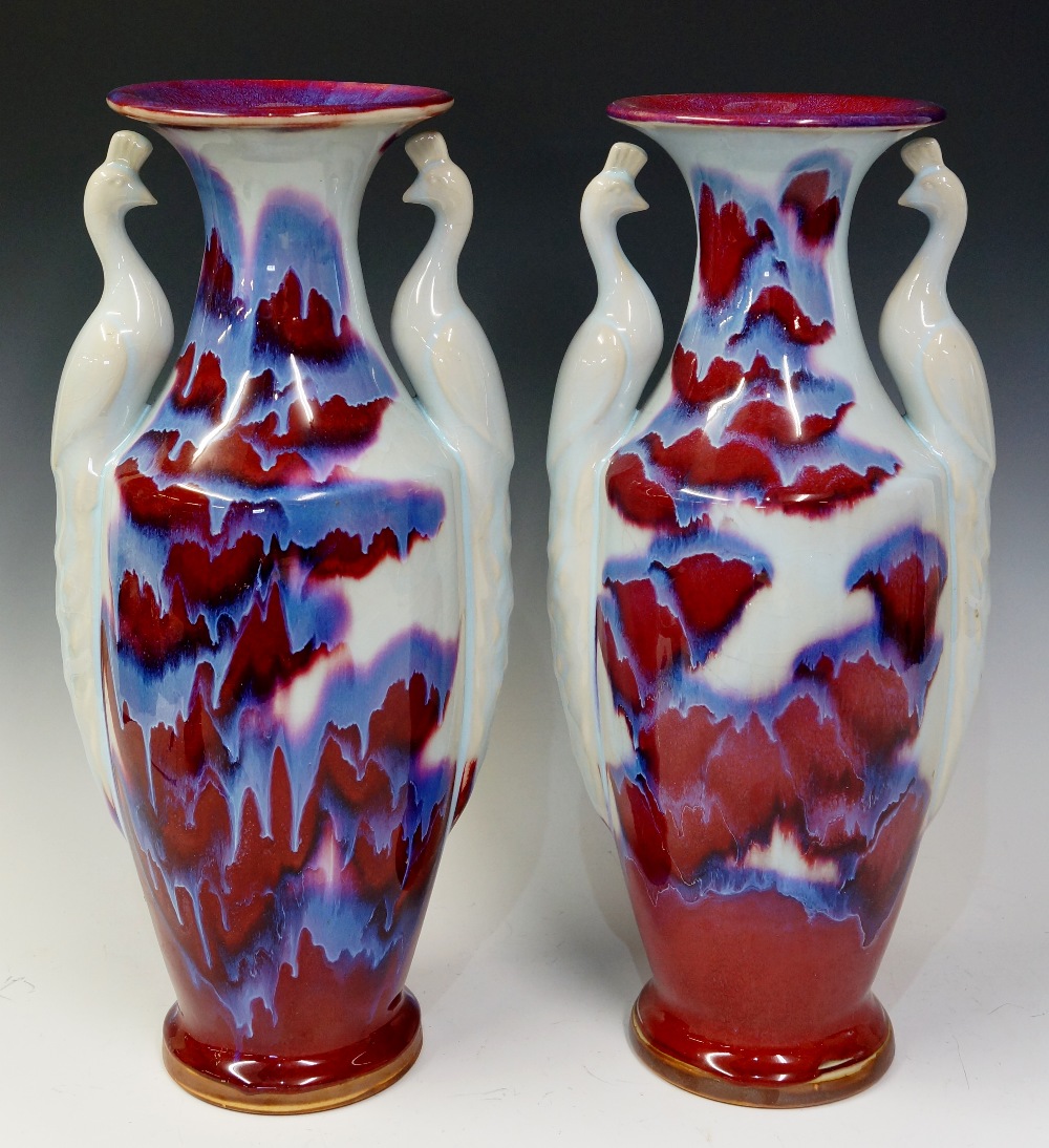 A pair of Jun ware porcelain vases modelled with stylised peacock handles,