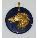 A Continental lapis lazuli pendant mounted with a gold coloured metal horse's head with red