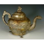 An Indian silver coloured metal teapot the hinged domed cover with deity riding a lion,