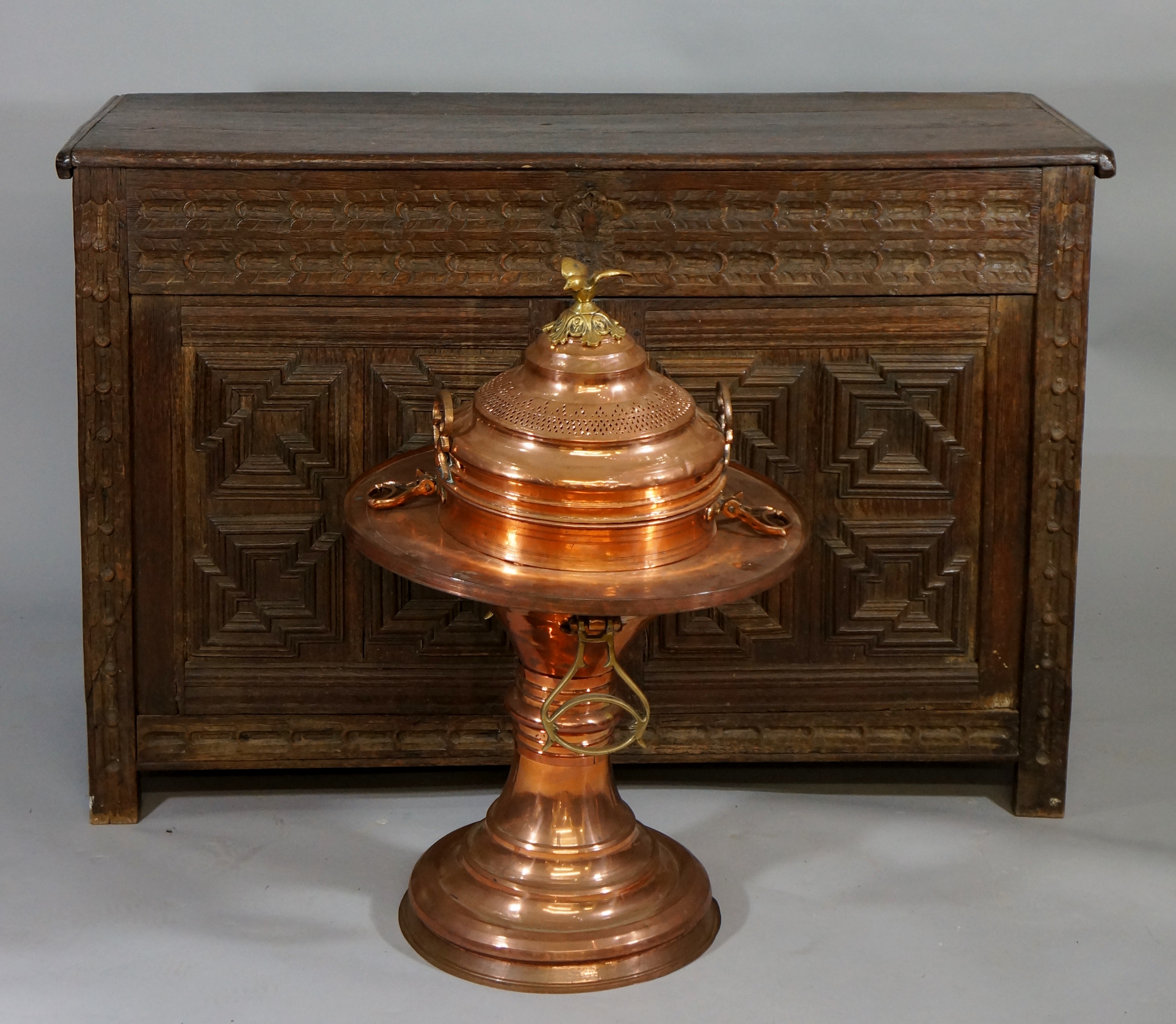 A Continental spun copper pedestal brazier with liner and cover, with bird finial,