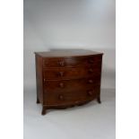 A George III mahogany bow-front commode outlined with boxwood stringing fitted four long graduated,