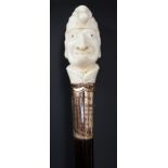 A walking stick the ivory top finely carved as Mr Punch above a gold plated collar inscribed