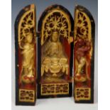 A Chinese red and gilt travelling folding shrine carved with Deistic figures beneath pierced