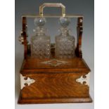 A late Victorian silver mounted oak two bottle tantalus and games compendium,