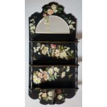 A Victorian black papier maché set of wall shelves, floral decorated,