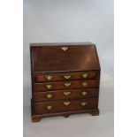 An early George III mahogany bureau the fall-flap above pair of slides and four long graduated